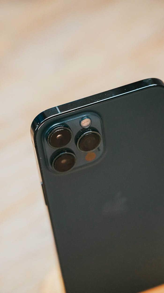 Detailed close-up of a smartphone with a triple camera lens, showcasing advanced photography features.